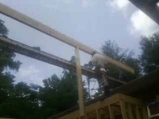 Carpenter setting a ridge beam over a new addition frame — Ice Dam Removal by Roofing Brothers in Woodrow