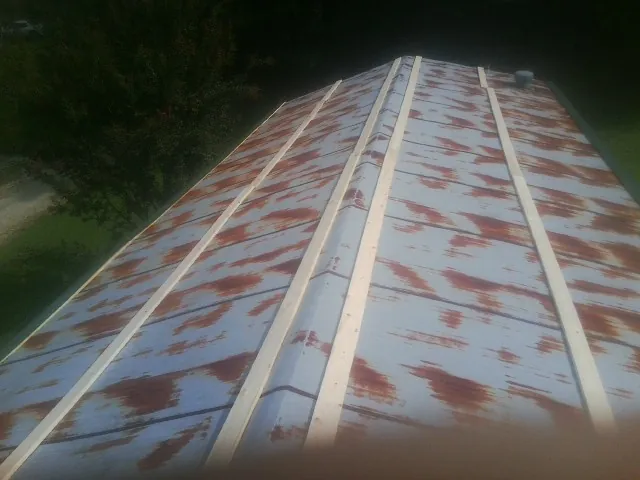 Rusted metal roof panels with new wood purlins before replacement — Storm Damage Roof Repair in Woodrow by Roofing Brothers